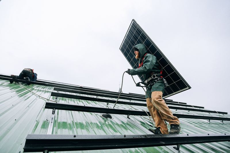 Solar installers working on a rooftop photovoltaic array